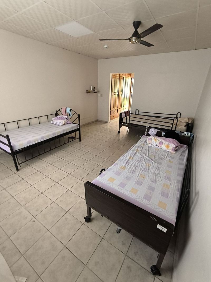 Habitación con dos camas ajustables, piso de cerámica y ventilador de techo